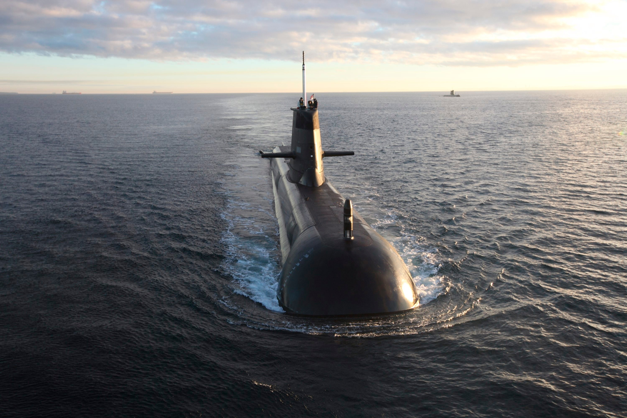 A submarine coasting into the water.
