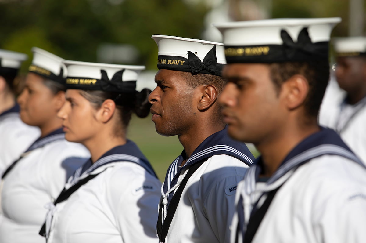 A line of sailors in uniform standing together.