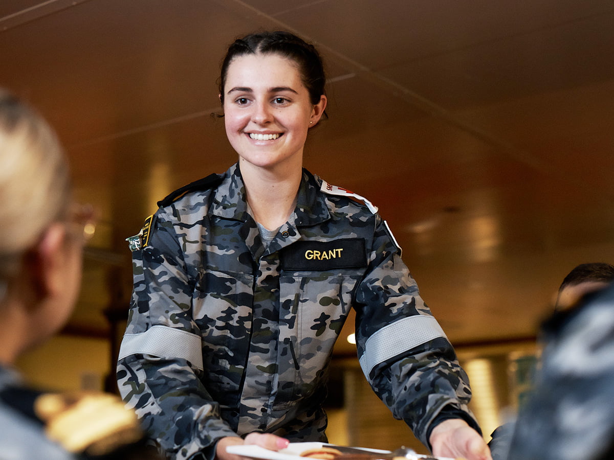 A woman in uniform smiles.